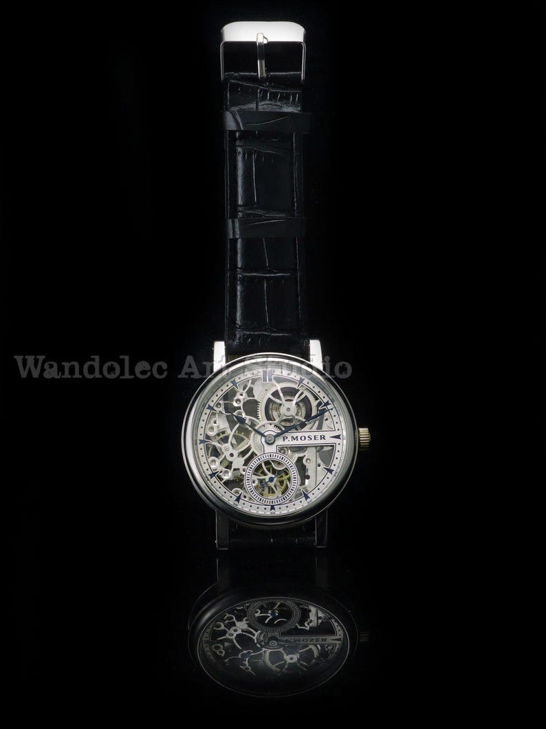 May include: A silver-toned skeleton watch with a black leather band. The watch face reveals intricate internal mechanisms, with the brand name "P. MOSER" visible. The watch is set against a black background, with a reflection below.