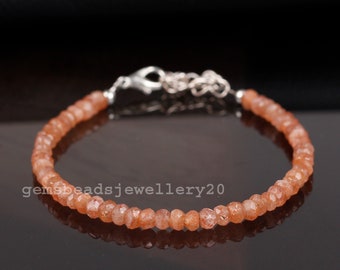 May include: A delicate bracelet made with small, faceted, orange sunstone beads. The bracelet has a silver clasp and is approximately 7 inches in length.