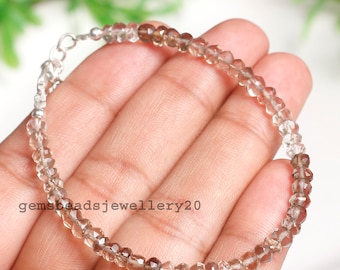 May include: A silver bracelet with faceted smoky quartz beads. The beads are graduated in size, with the larger beads at the bottom of the bracelet. The bracelet is approximately 7 inches in length.