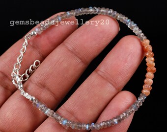 May include: A silver chain bracelet with a graduated design of faceted labradorite and sunstone beads. The bracelet has a lobster clasp closure.
