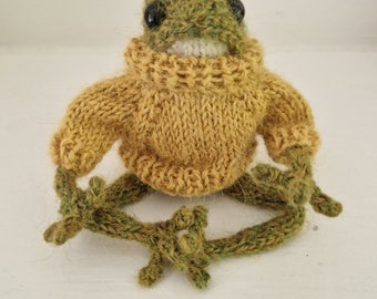 Hand knitted frog wearing a sweater. Tiktok frog
