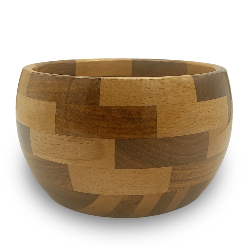 May include: A wooden bowl with a unique geometric pattern made from different shades of wood. The bowl is round and has a smooth, polished finish.