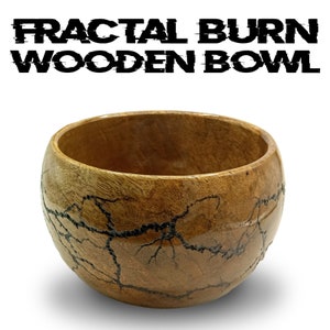 May include: A wooden bowl with a fractal burn design. The bowl is brown with black lines throughout. The bowl is round and has a smooth surface.