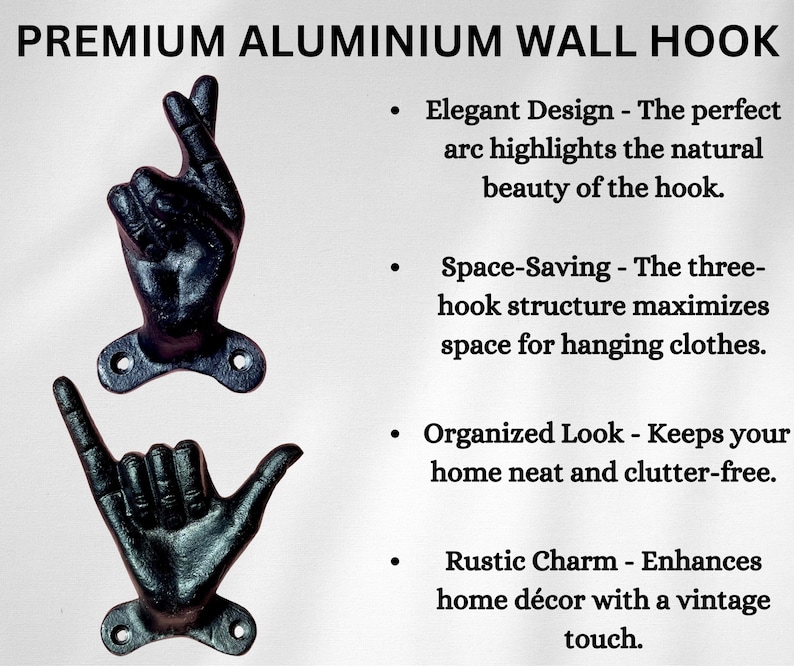 May include: Two black aluminum wall hooks shaped like hands, one with fingers crossed and the other with a shaka sign. The hooks are mounted on a white background and are designed for hanging clothes.