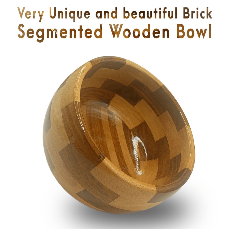 May include: A wooden bowl made of segmented pieces of wood. The bowl is light brown and has a natural wood finish. The bowl is in the shape of a half-sphere and is tilted to the side.
