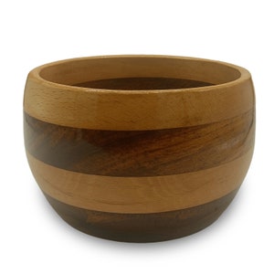 May include: A wooden bowl with a striped pattern in shades of brown and light wood. The bowl is round and has a smooth, polished finish.
