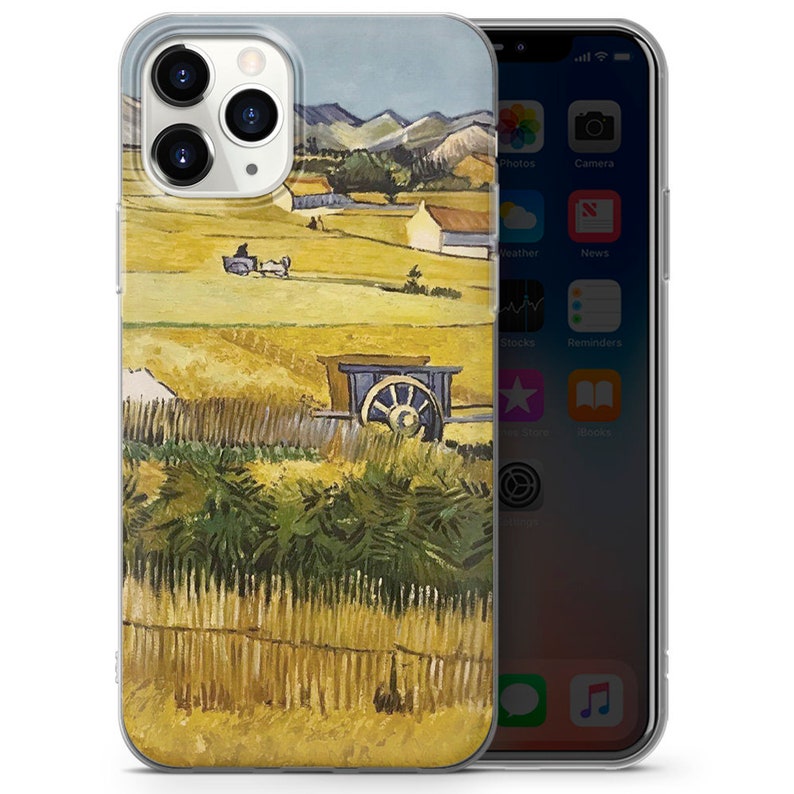 May include: A clear phone case with a painting of a rural landscape. The painting features a field of wheat, a wooden fence, a wagon, and a farmhouse in the distance. The colors are warm and earthy, with shades of yellow, brown, and green.