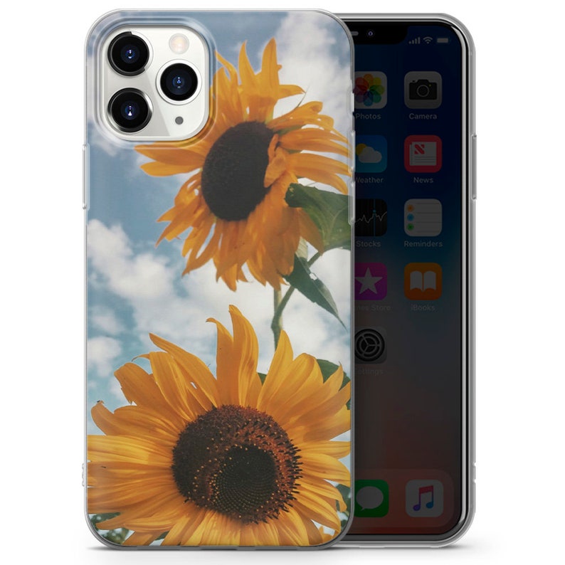 May include: A clear phone case with a design of two yellow sunflowers against a blue sky with white clouds. The sunflowers are in focus and the sky is out of focus.