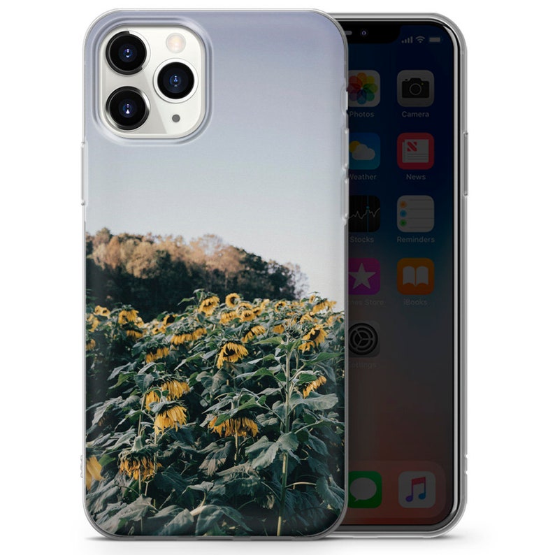 May include: A clear phone case with a design of a field of sunflowers. The sunflowers are yellow and the leaves are green. The background is a blue sky with some clouds.