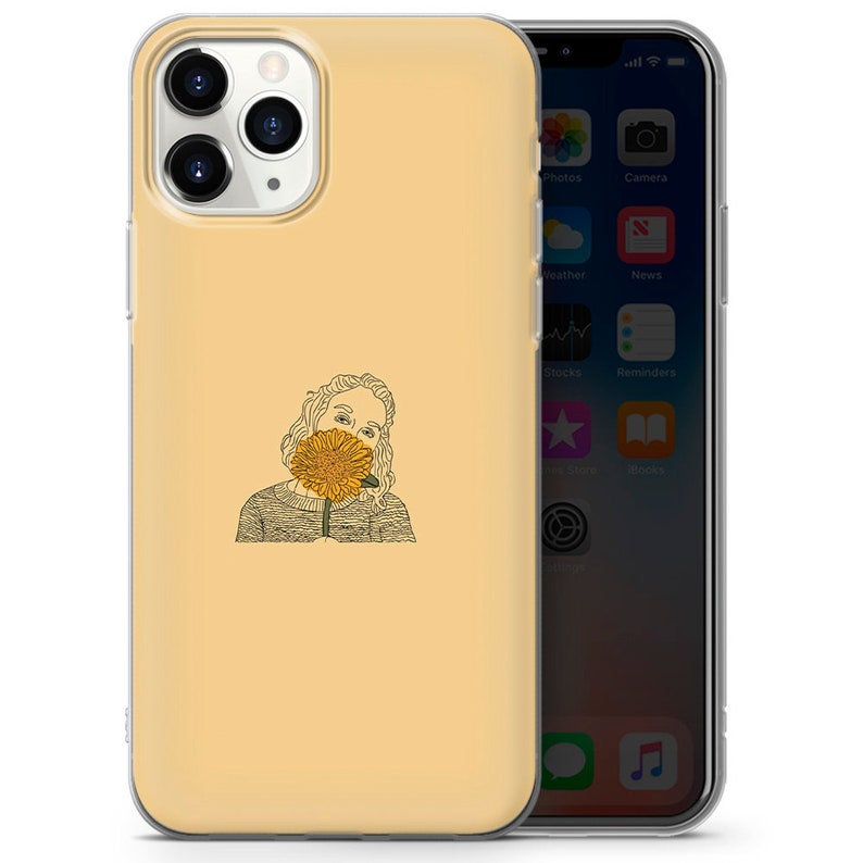 May include: A yellow phone case with a line drawing of a person holding a sunflower in front of their face.
