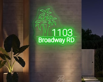 May include: A bright green neon sign mounted on a wall, featuring a palm tree graphic above the text 1103 Broadway RD. The sign is illuminated against a dark exterior, displaying the address clearly with a glowing, vibrant light effect.