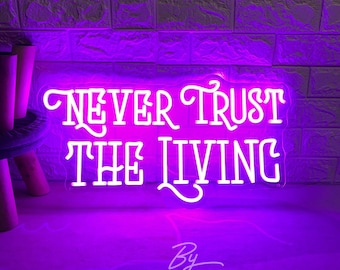 May include: White neon sign with the text "NEVER TRUST THE LIVING" on a purple background. The sign is lit up and has a cursive font. The text "By ZPZ Neon Custom" is written in white below the sign.