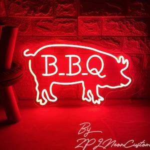 May include: Red neon sign shaped like a pig with the text "B.B.Q." inside. The sign is lit up and glowing against a brick wall background.