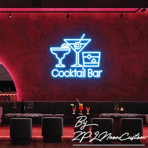 May include: A neon sign with a blue outline of three cocktail glasses and the words "Cocktail Bar" in white. The sign is mounted on a red wall. The image also shows a bar setting with seating and tables.