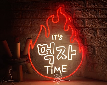May include: Red neon sign shaped like a flame with the text "It's 맥자 Time" in white neon. The sign is on a brick wall background.