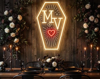 May include: A coffin-shaped neon sign featuring the letters M and V in yellow, a small heart symbol with a cross, and a larger red heart with radiating lines. The sign is mounted on a dark wood wall above a dining table with floral arrangements.