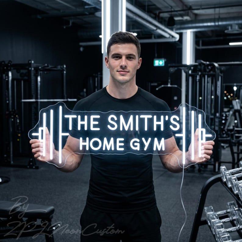 May include: A white neon sign in the shape of a barbell, with the text "THE SMITH'S HOME GYM". The sign is held by a person in a gym setting, with exercise equipment visible in the background.