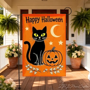 May include: A rectangular orange garden flag featuring the black text Happy Halloween at the top. The design includes a black cat with yellow eyes, a carved jack-o'-lantern, a white crescent moon, three white stars, and white ivy leaves.