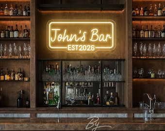 May include: A neon sign with the text "John's Bar - EST 2026" in a rectangular frame. The sign is illuminated in a warm, inviting glow. The bar is stocked with bottles and glassware, with a wooden bar and leather bar stools.