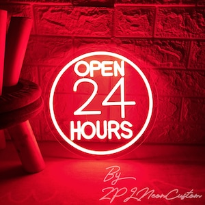 Op de afbeelding: Een wit neon-bord met een rode cirkel eromheen. Het bord zegt "Open 24 uur".