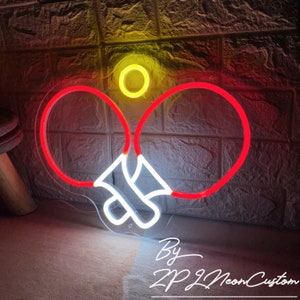 May include: A neon sign depicting a tennis or ping pong theme. The sign features two red rackets, a yellow ball, and white accents. The text "By ZP Neon Custom" is visible at the bottom.