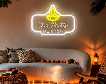 May include: A custom neon sign featuring a bright yellow diya lamp icon at the top, with the white text The Patels and Diwali 2026 displayed below. The sign is mounted on a clear acrylic backing with a rounded rectangular shape and soft white glow.