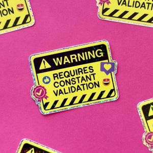 Könnte beinhalten: Ein Satz von neun gelben und schwarzen Warnhinweisaufklebern mit holografischem Finish. Jeder Aufkleber zeigt den Text "WARNING" und "REQUIRES CONSTANT VALIDATION" mit verschiedenen Emojis und Symbolen.