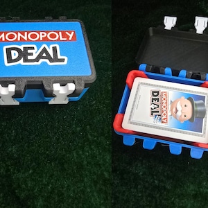 May include: A blue and black Monopoly Deal card game case, closed and open. The closed case has the game title in white and red. The open case reveals the cards with the Monopoly Deal logo and character.