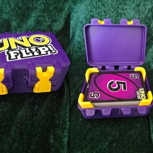 May include: Two purple UNO FLIP! card game cases, one closed and one open. The open case displays a deck of cards with a large number 5. The cases have yellow clasps and the game's logo is visible on the closed case.