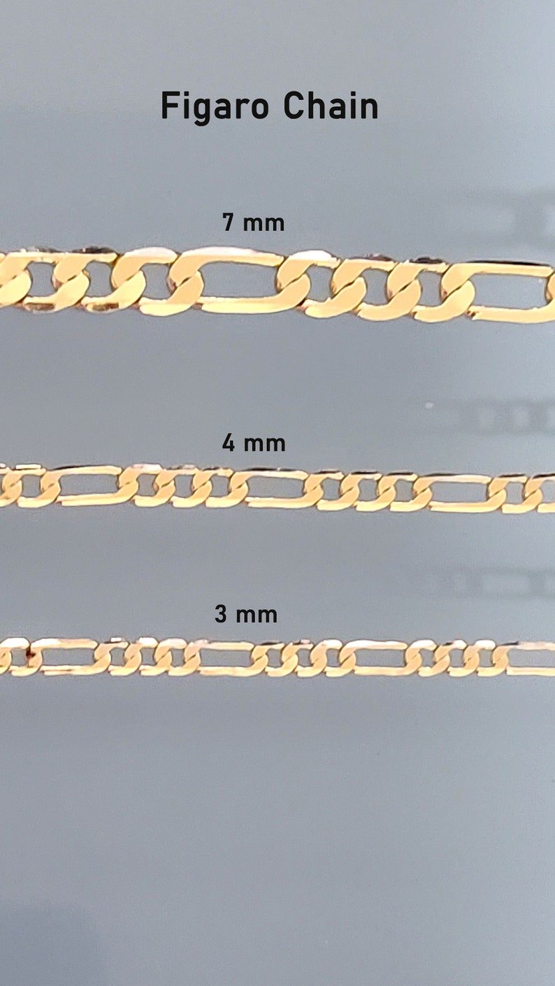 May include: Three gold Figaro chains in different sizes: 7 mm, 4 mm, and 3 mm. The chains are shown against a light gray background.