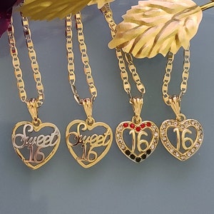 May include: Four gold necklaces with heart-shaped pendants. Two pendants say "Sweet 16" in gold lettering. One pendant has a red and black rhinestone design with the number "16" in the center. The last pendant has a clear rhinestone design with the number "16" in the center.