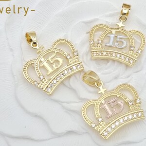 May include: Three gold-toned crown pendants, each featuring the number 15 in the center. The base of each crown is embellished with a row of small, clear, sparkling stones. Each pendant includes a small bail at the top for attachment to a chain.