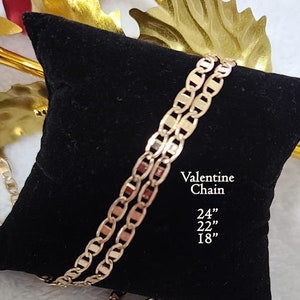 May include: Two gold Valentine chains on a black velvet cushion. The chains are 24", 22", and 18" long.