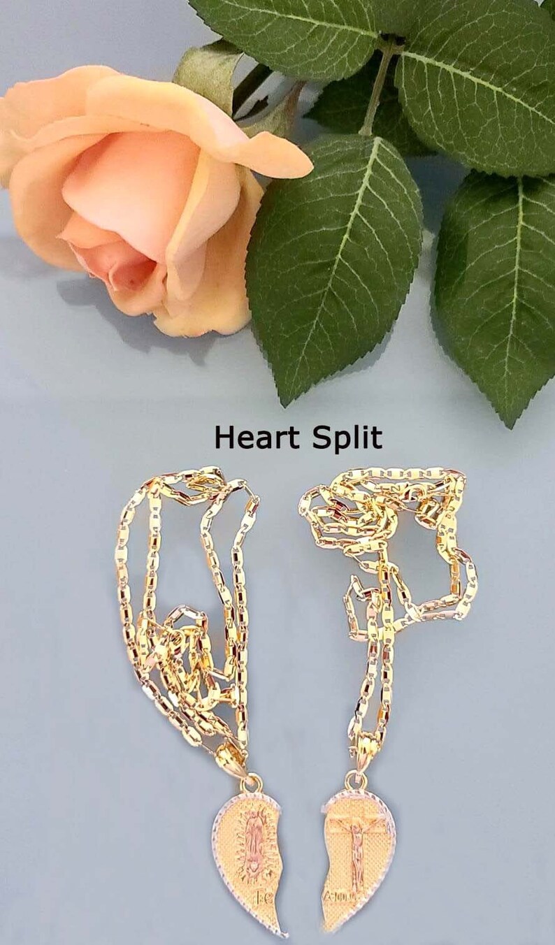 May include: Two gold necklaces with heart-shaped pendants. The pendants are broken in half, with one half featuring a depiction of the Virgin Mary and the other half featuring a depiction of Jesus Christ. The text "Heart Split" is visible above the necklaces.