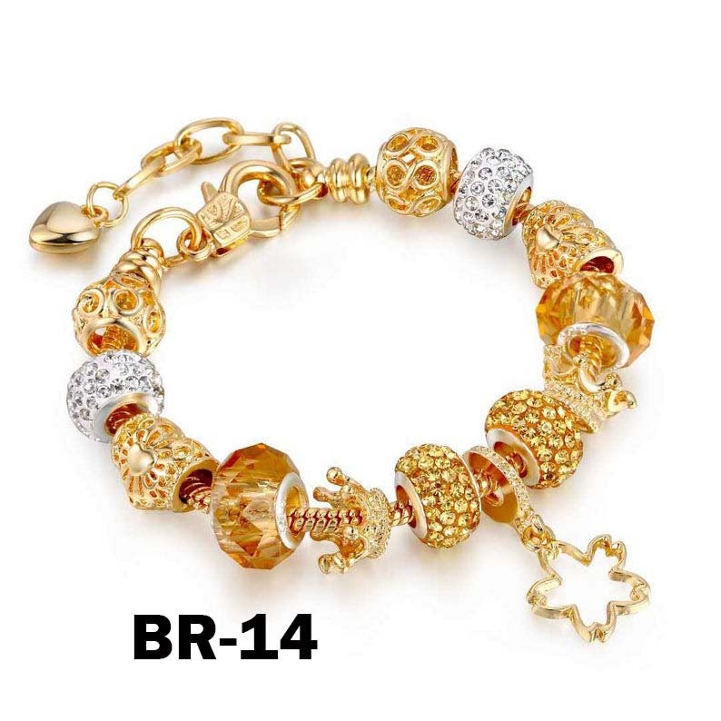May include: Gold-toned charm bracelet with various decorative beads, including crystal-studded spheres, faceted amber-colored beads, and a crown charm. The bracelet features a heart-shaped clasp and a dangling flower charm. The text "BR-14" is visible.