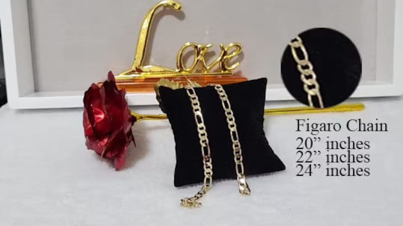 May include: Two gold Figaro chains on a black velvet cushion. The chains are available in 20", 22", and 24" lengths.  Figaro Chain 20" inches 22" inches 24" inches