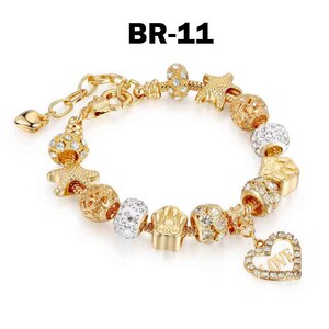 May include: Gold-toned charm bracelet with various decorative beads, including starfish, openwork spheres, and crystal-studded elements. A heart-shaped charm with the word "LOVE" hangs from the bracelet. The text "BR-11" is in the upper left corner.