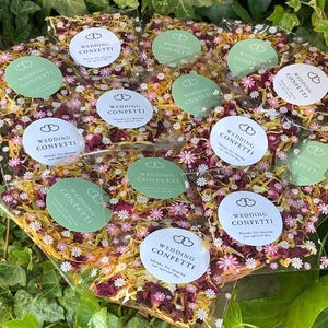 100 coriandoli per matrimonio in petali di rosa e calendula essiccati, color verde salvia e bianchi, in confezioni colorate. Sacchetti biodegradabili per coriandoli per matrimonio in colori verde e bianco.