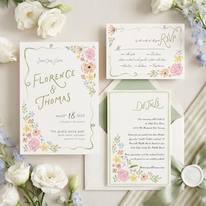 May include: A wedding invitation suite featuring a Save Our Date card, an RSVP card, and a Details card. Each white card displays gold cursive text, floral illustrations in pink, yellow, and blue, and green decorative borders.