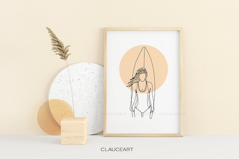 Pu&ograve; includere: Stampa di arte lineare di una donna in piedi su una tavola da surf con un cerchio color pesca dietro di lei. La stampa &egrave; in una cornice di legno e su uno sfondo bianco.