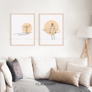 Pu&ograve; includere: Due stampe minimaliste di arte di linea di una ragazza che fa surf con una tavola da surf. Le stampe sono incorniciate in una cornice di legno chiaro e hanno uno sfondo pesca. Le stampe sono appese a un muro bianco sopra un divano beige.