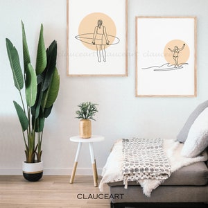 Pu&ograve; includere: Due stampe minimaliste di arte lineare di una donna che fa surf. Le stampe sono incorniciate in legno naturale e hanno uno sfondo bianco con un cerchio color pesca dietro la surfista. Le stampe sono appese a un muro bianco.