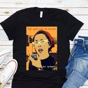 May include: Black t-shirt with a graphic of a woman with a microphone and the text "Fight against racism and polarization" and "Yuri Kochiyama".