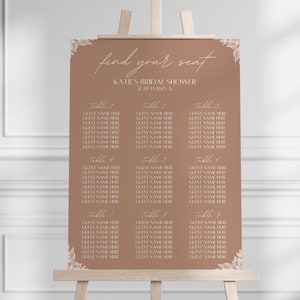 May include: A brown seating chart with white text for a bridal shower. The chart has the title "find your seat" and "KATIE'S BRIDAL SHOWER" with the date "07.11.2025". The chart lists tables 1 through 9 with guest names.