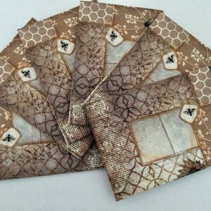 May include: A set of six brown envelopes with a bee and honeycomb pattern. The envelopes have a vintage look with a distressed, faded appearance. The envelopes are perfect for adding a touch of rustic charm to your correspondence.