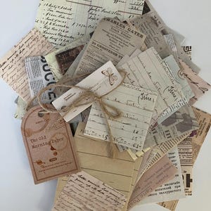May include: A stack of vintage paper ephemera with handwritten notes, old newspaper clippings, and a tag that reads "The Old Morning Paper". The papers are tied together with twine and a decorative butterfly tag.