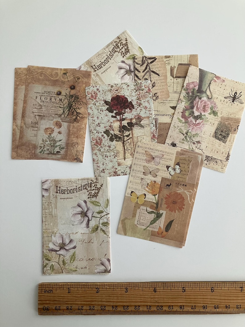 May include: A set of vintage-style paper ephemera featuring floral illustrations and botanical designs. The papers are printed on a cream-colored background with brown and black text. The text includes the words "Herboristerie" and "Florvm Imagines".