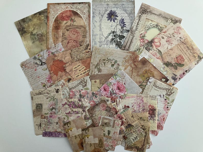 May include: A collection of vintage-style paper ephemera featuring floral designs, handwritten text, and delicate patterns. The papers are in shades of cream, brown, and pink, with a distressed, aged look.