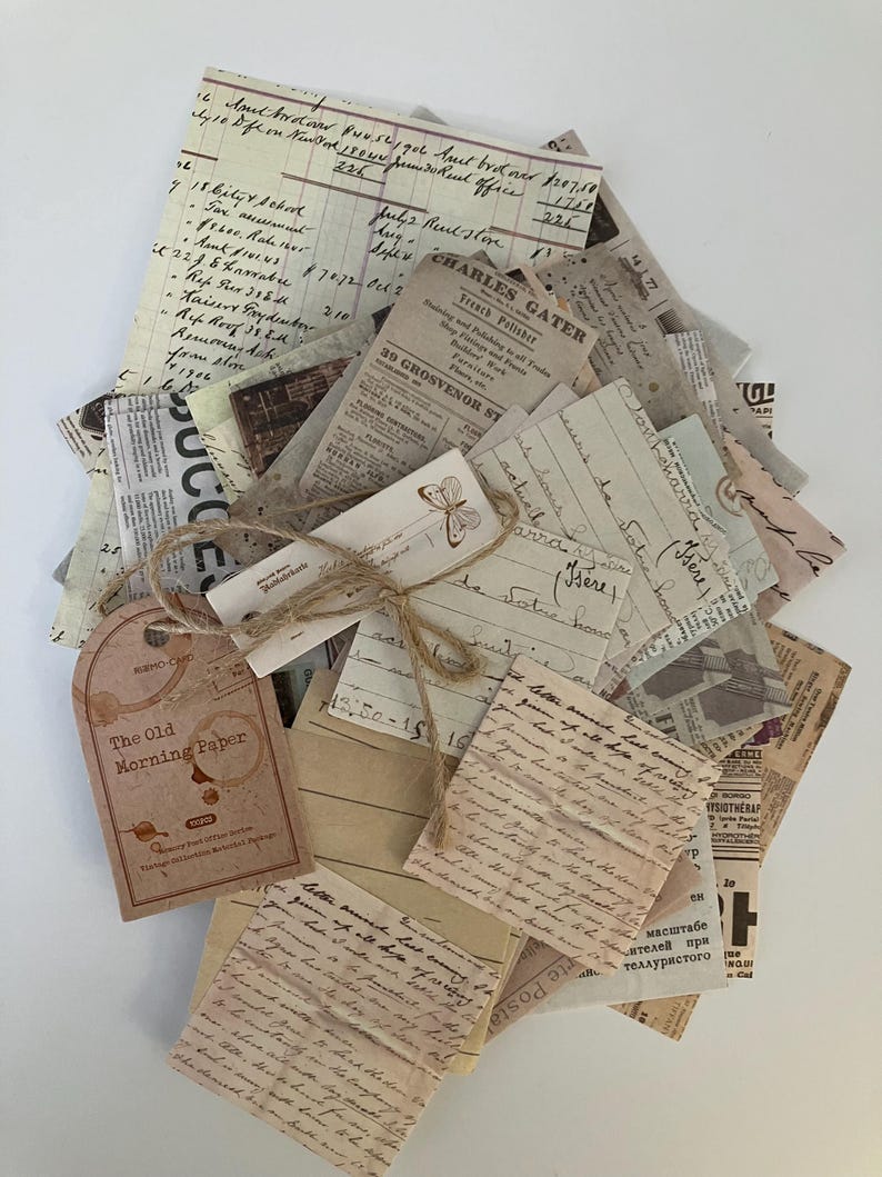 May include: A stack of vintage paper ephemera with handwritten notes, newspaper clippings, and a tag that reads "The Old Morning Paper". The papers are tied together with twine and have a rustic, aged look.