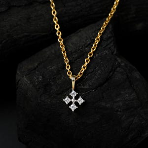 Op de afbeelding: Een gouden ketting met een klein diamant kruis hanger. De hanger heeft vijf diamanten die in een kruisvorm zijn gezet.